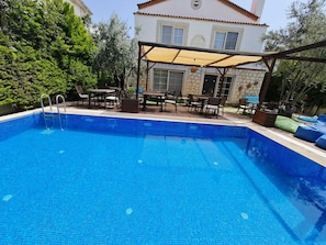 A swimming pool with a tiled deck, outdoor furniture, and a covered seating area. - Alaçatı Otel Rebetiko (Cesme)