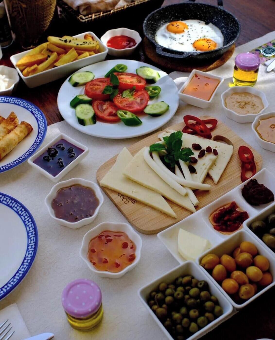 A table with various food items including eggs, cheese, olives, and vegetables.