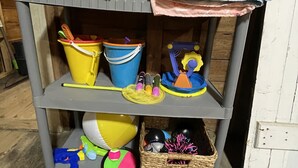 A gray shelf with folded towels, two buckets, and a toy. - Meredith Charmer-walk to lake, town, shops, & boat launch (Meredith)