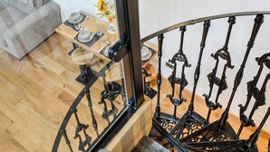 A staircase with a wooden finish and ornate black metal railings. - 2 bedroom accommodation in Kirriemuir (Kirriemuir)
