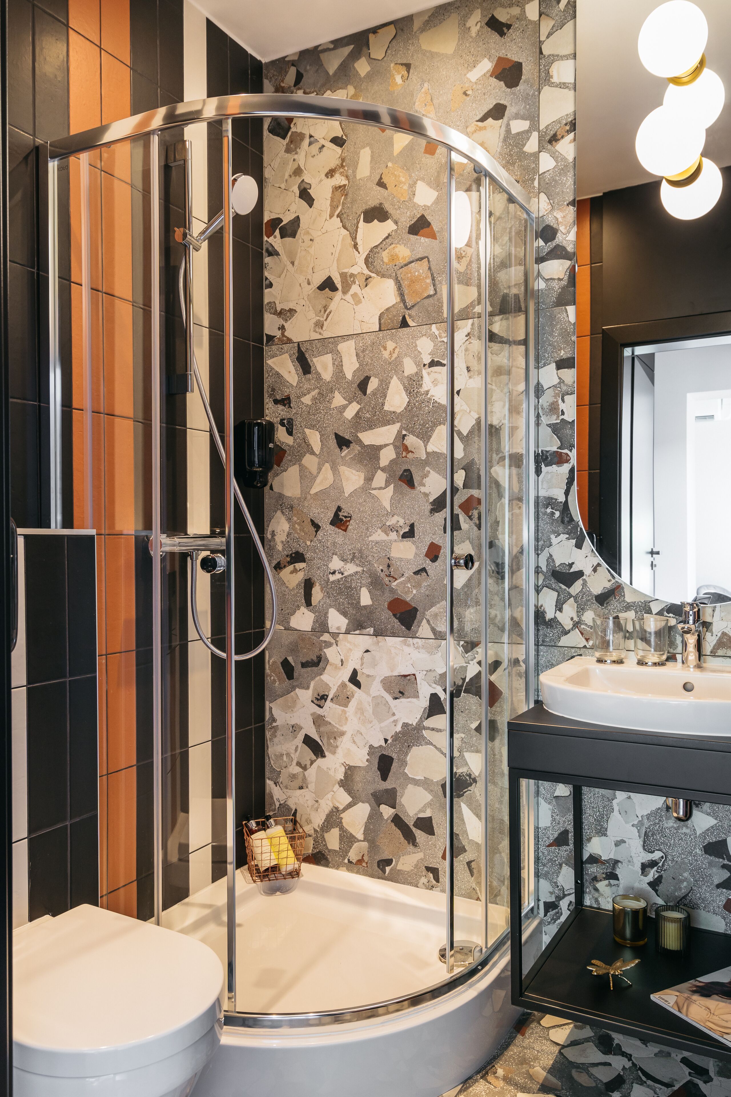 A modern bathroom with a glass-enclosed shower, a white bathtub, and a sink with a mirror above it.