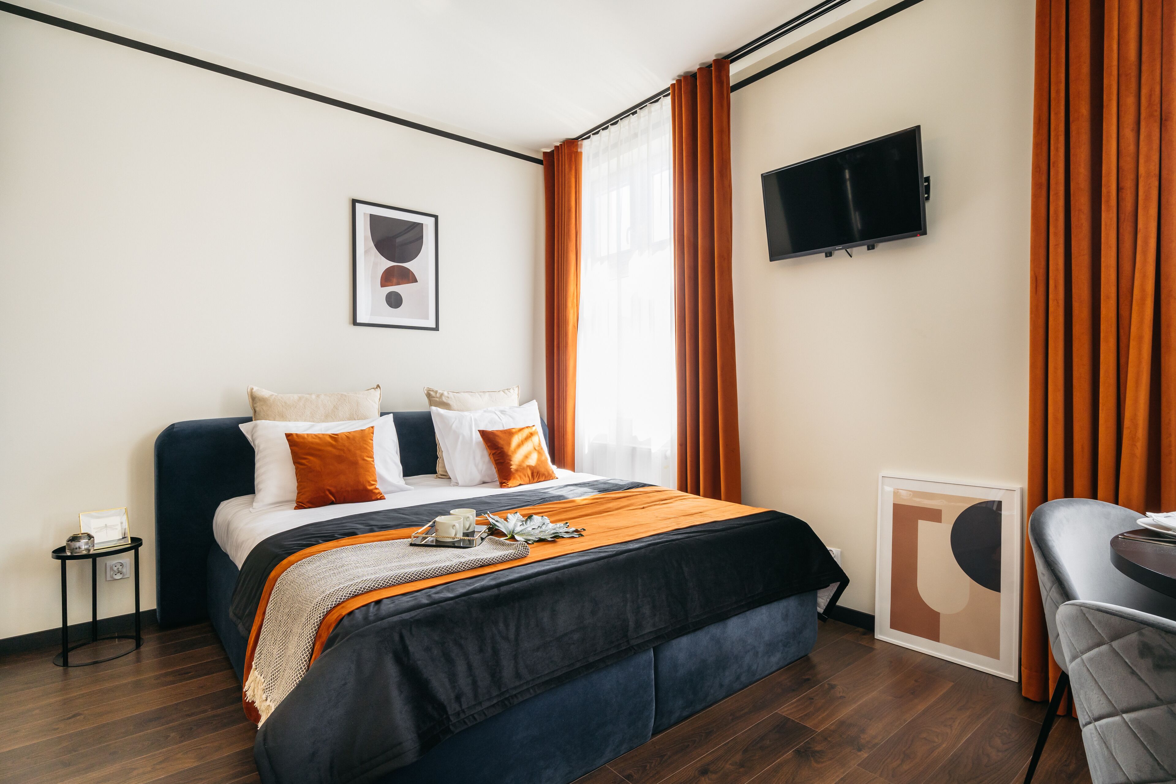 A hotel room with a bed, a TV, and a desk.