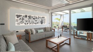 Una sala de estar moderna con un sofá, una mesa de centro y un televisor de pantalla plana.