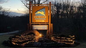 Señal del Snowshoe Mountain Inn con flechas direccionales y un logotipo.