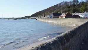 A coastal town with a stone sea wall, houses with red roofs, and boats in the water. - 2 bedroom accommodation in Cluny, near Kirkcaldy (Cluny, near Kirkcaldy)