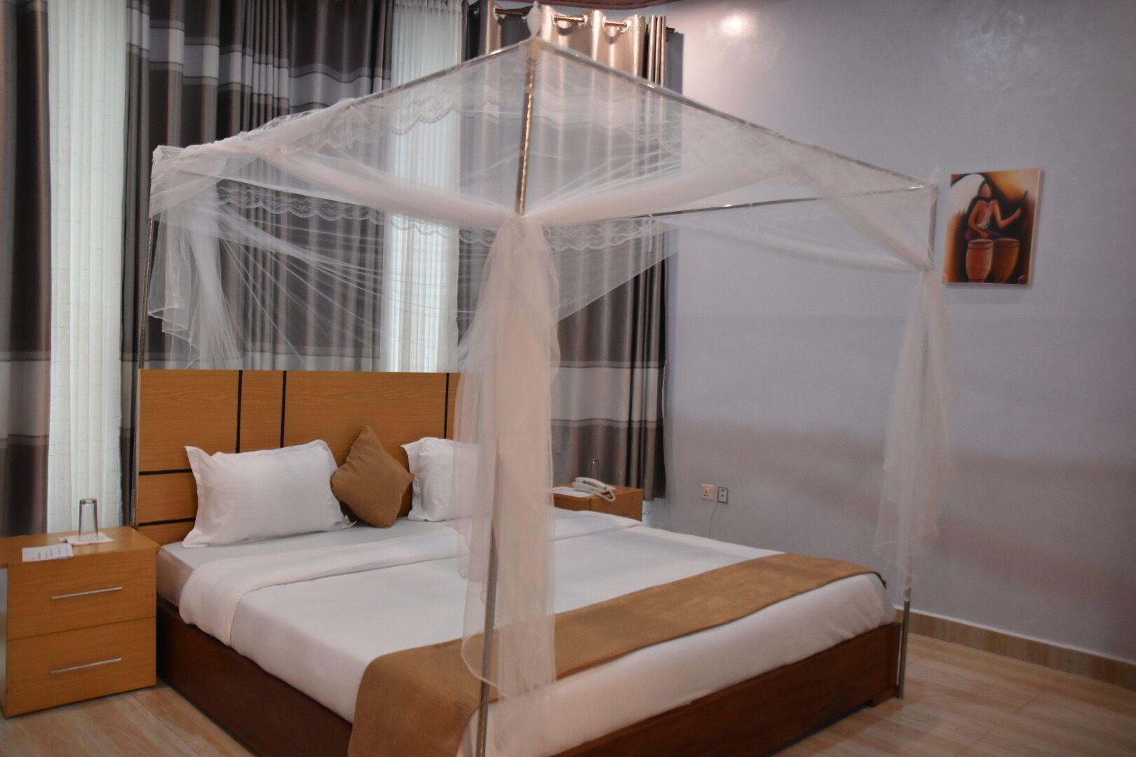 A neatly made bed with a wooden headboard, a bedside table with a lamp, and a nightstand.