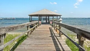 A wooden pier leading to a gazebo over water.