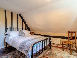 A bedroom with a bed, a chair, a radiator, and a sloped ceiling. - What a delight; the perfect place to relax and unwind. (Shelfhanger, Nr Diss)