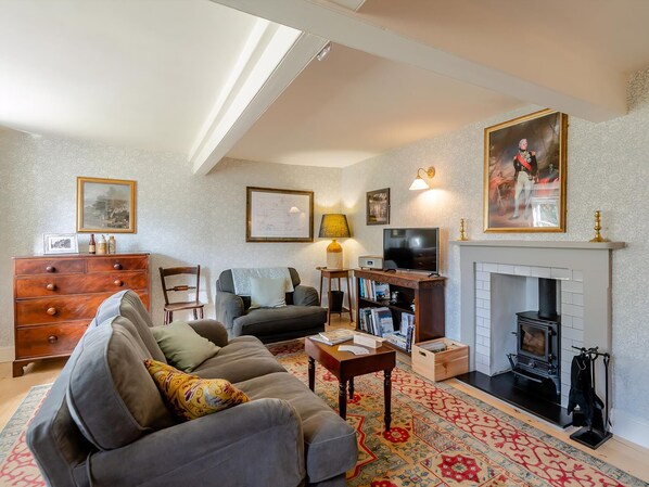 A cozy living room with a fireplace, a sofa, a television, and a bookshelf. - What a delight; the perfect place to relax and unwind. (Shelfhanger, Nr Diss)