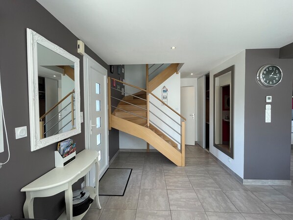 A modern interior with a staircase, a bench, a mirror, and a clock on the wall. - Fenced-in 4-star house—direct access to the Etel River (300 meters) (Plouhinec)