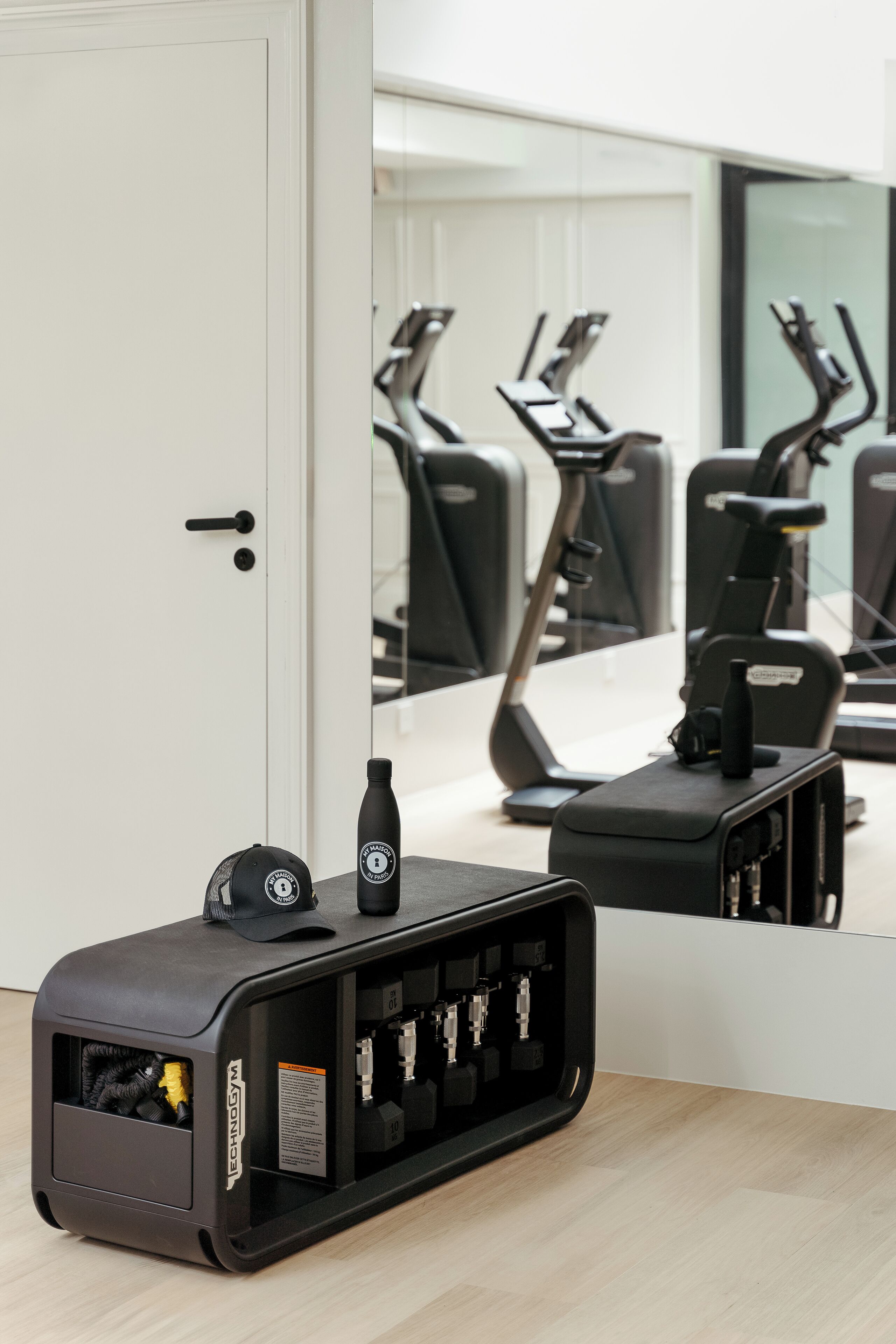A gym with exercise equipment, a water bottle, and a charging station.