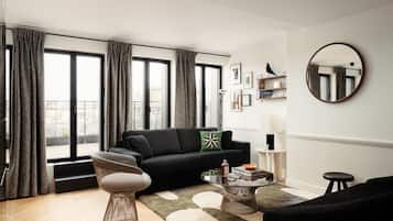 A modern living room with a black sofa, a round coffee table, and a large window with curtains.