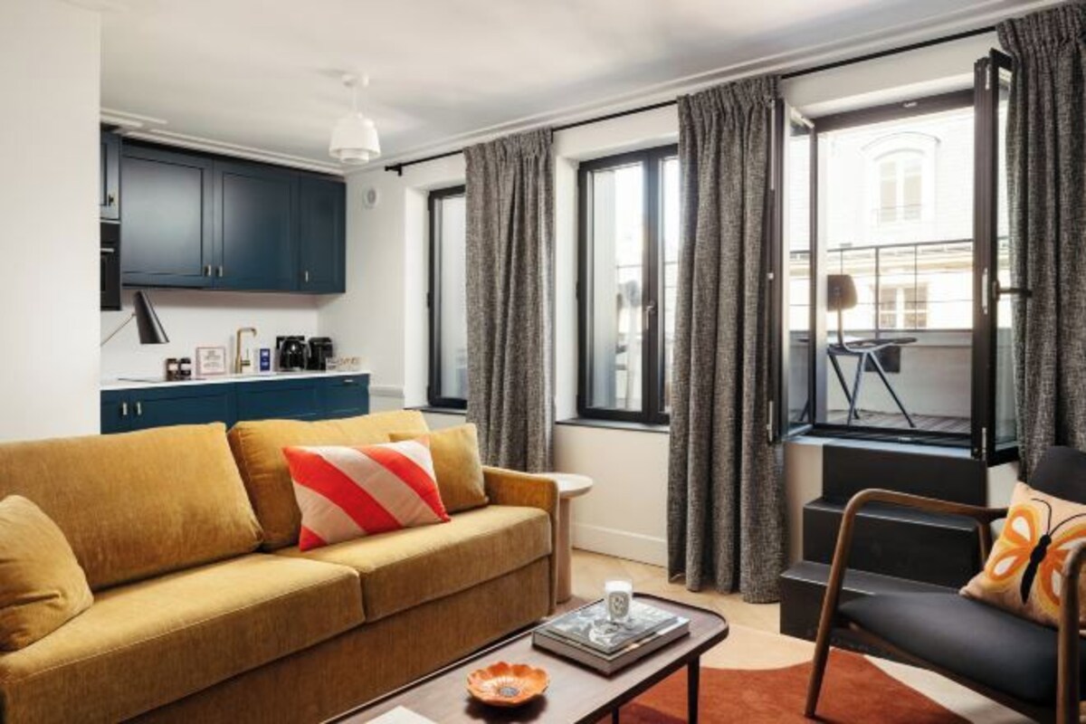 A modern living room with a sofa, coffee table, and a view of a balcony.