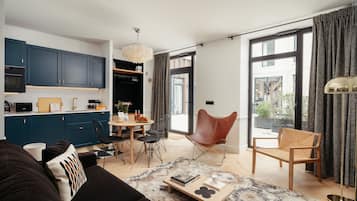 Ein modernes Wohnzimmer mit einer Couch, einem Couchtisch und einem Essbereich mit Stühlen und einem Tisch.