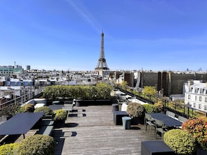 A rooftop terrace with outdoor seating, a view of the Eiffel Tower, and surrounding cityscape. - My Maison In Paris - Invalides (Paris)