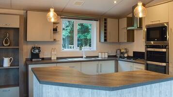 A modern kitchen with a central island, stainless steel appliances, and pendant lighting.