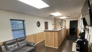 A hotel lobby with a leather sofa, a wooden reception desk, and a coffee machine. - The Armadillo Hotel Carlsbad (Carlsbad)