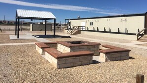 A courtyard with a fire pit, seating areas, and a covered structure. - The Armadillo Hotel Carlsbad (Carlsbad)