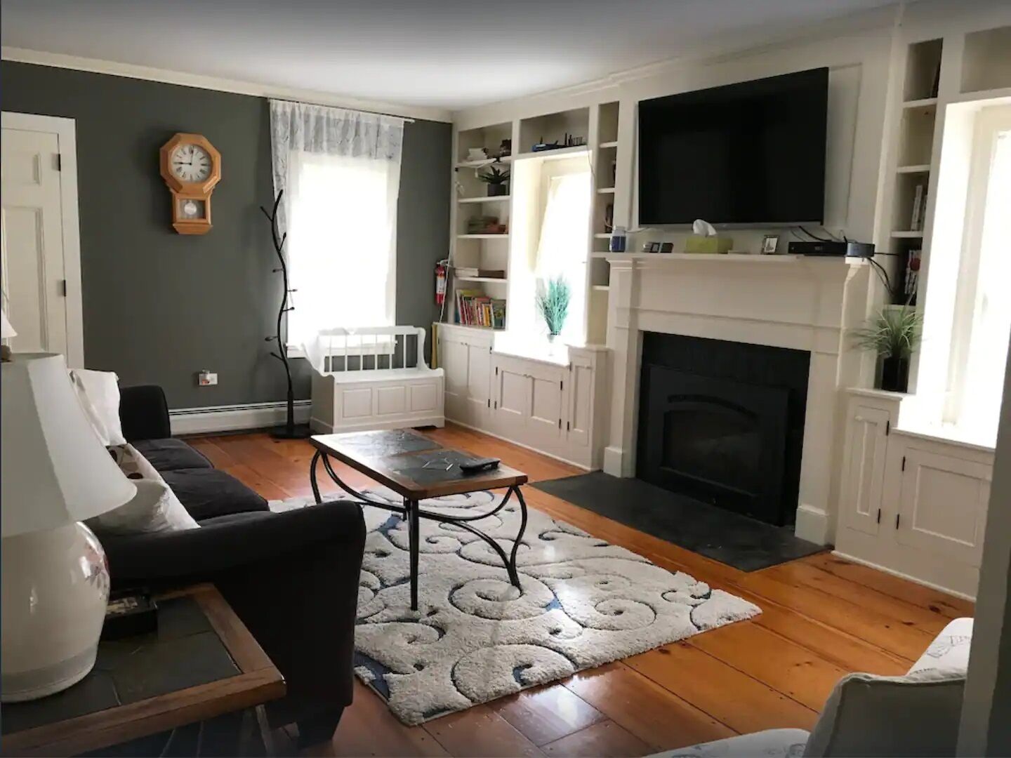 Un salon avec une cheminée, un canapé, une table basse et un téléviseur.