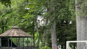 A gazebo, outdoor seating, and a swing set in a garden setting.