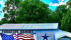 A building with a sign reading "Paradise Resort" and large American flags.
