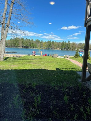 A lakeside view with a grassy area, trees, and a dock. - Lake House on Jose Lake (South Branch)