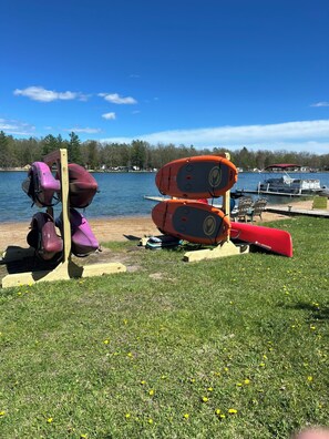 A lakeside setting with canoes and kayaks on a wooden stand. - Lake House on Jose Lake (South Branch)