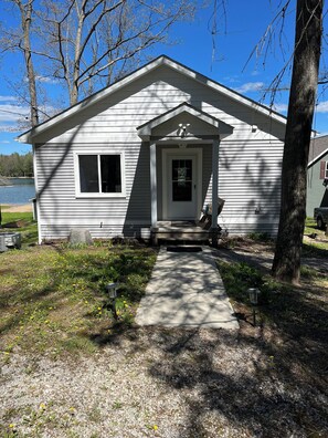 A small, single-story cabin with a front porch, a door, and a window. - Lake House on Jose Lake (South Branch)