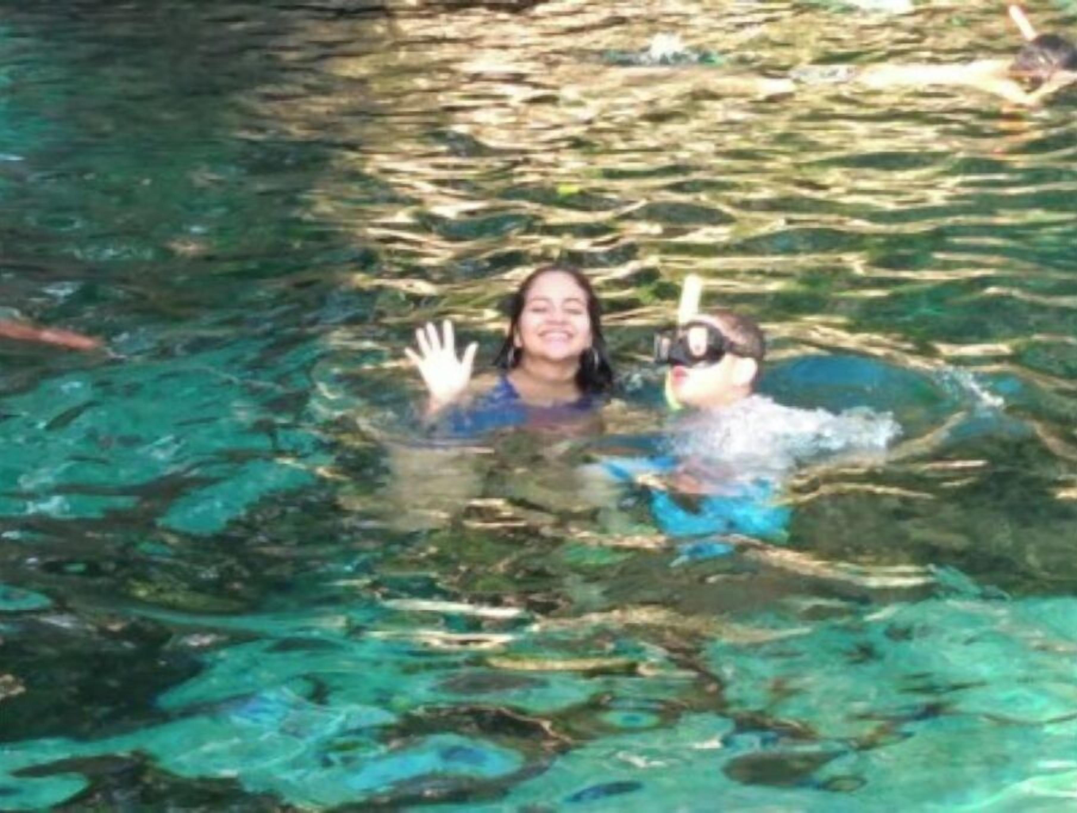 A person in a swimming pool with clear water.