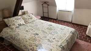 A bedroom with a bed, a small round table, a hanging chair, and a radiator. - House with garden and free parking, 2 minutes from Le Clos Lucé (Amboise)