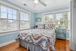 A bedroom with a bed, a nightstand, a dresser, and a ceiling fan. - Charming & Fun! Vacation home w/private pool, game room, short stroll to beach-perfect for families (North Myrtle Beach)