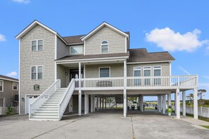 A two-story house with a covered porch and a staircase leading to the entrance. - Spacious family channel home-great views, boating, fishing, kayaking-close to the beach (North Myrtle Beach)