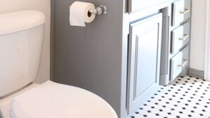A modern bathroom with a toilet, a sink with a mirror, and a shower area. - 5 Min away from TCU/Downtown/Stockyards/Dickies Arena (Fort Worth)