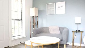 A modern living room with a grey sofa, a round white table with gold legs, a floor lamp, and two framed motivational posters on the wall. - 5 Min away from TCU/Downtown/Stockyards/Dickies Arena (Fort Worth)