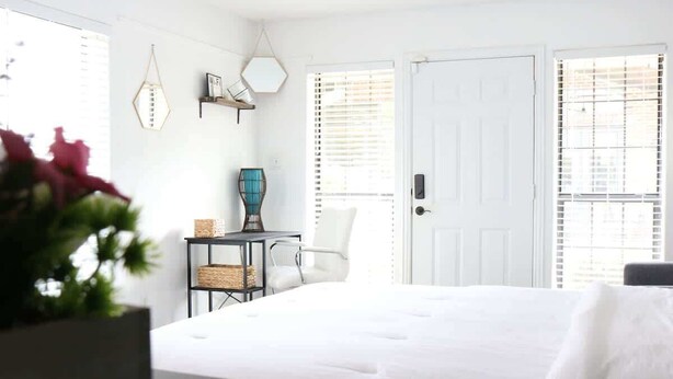 A bedroom with a large bed, a desk with a lamp, a chair, and a window with blinds. - 5 Min away from TCU/Downtown/Stockyards/Dickies Arena (Fort Worth)