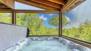 A hot tub with a view of a forest through large windows. - Blue Ridge Cabin- Amazing Porch, Game Room, 10 Min to Town! (Blue Ridge)