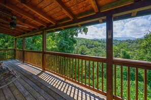 A wooden deck with a view of a forested mountain range. - Luxury Mountain Getaway 5 Minutes from Pigeon Forge Parkway! (Pigeon Forge)