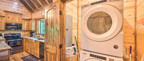 A compact kitchen with wooden cabinets, a microwave, stove, and a dishwasher.