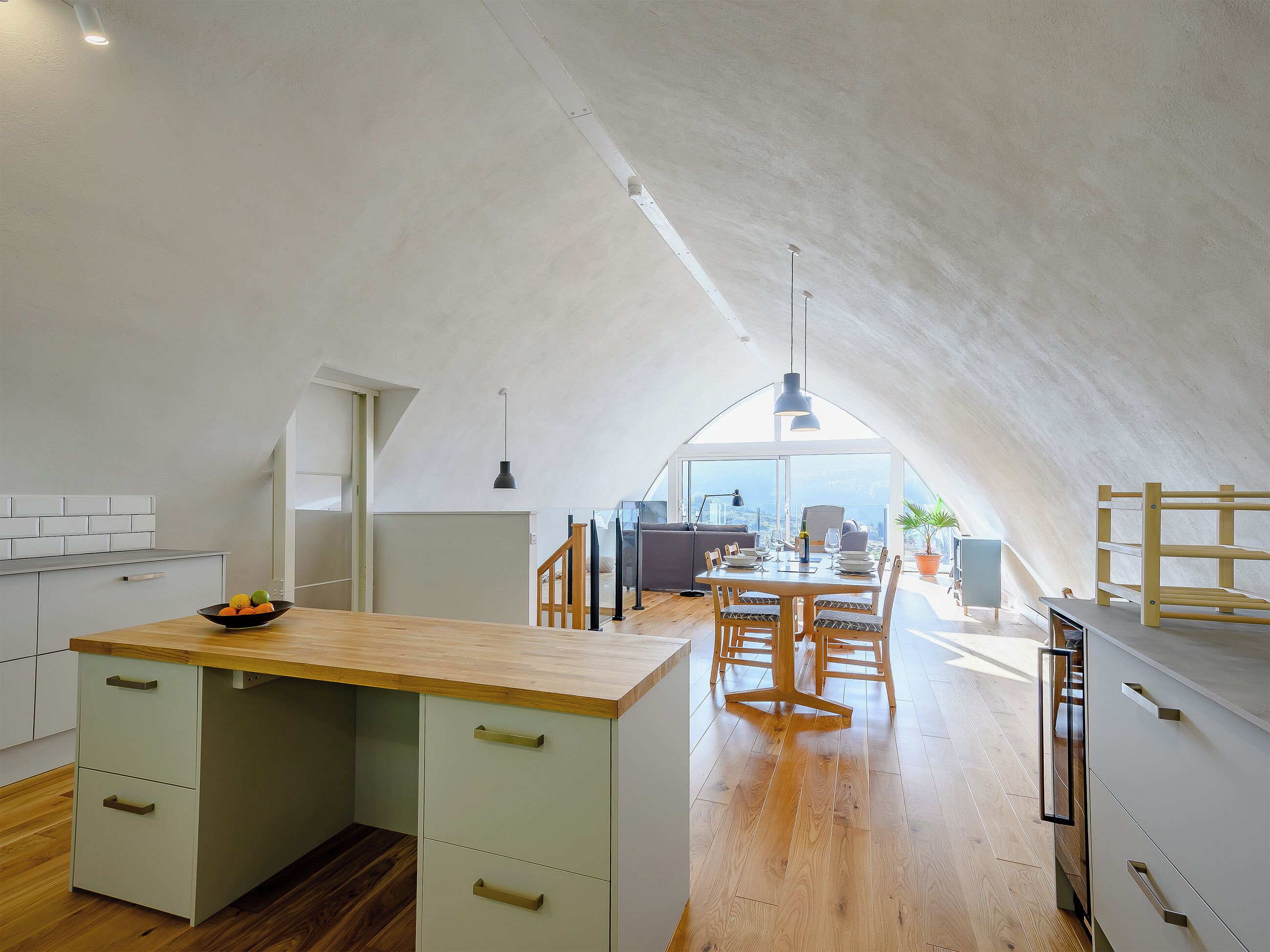 Una cocina moderna con encimera de madera y un comedor con mesa y sillas.