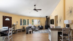 A spacious living area with a fireplace, a dining table with chairs, and a sofa.