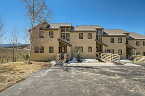 A multi-story building with a symmetrical facade, a covered driveway, and a small tree in the foreground. - Family 2bedroom with Loft, Lake Views, Amazing Location (Dillon)