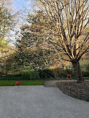 A tree-lined pathway with a gravel path and a red parking sign. - Gîte des Aillets, in the heart of the Revermont, close to the Jura. (Simandre sur suran)