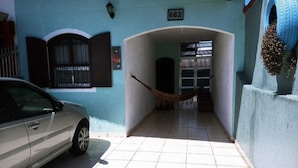 A narrow hallway with a hammock, a car parked on the left, and a building number 662. - Vacation Home in Praia Grande - 3 min. Beach (Praia Grande)