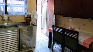 A kitchen with a sink, cabinets, and a dining area with a table and chairs. - Vacation Home in Praia Grande - 3 min. Beach (Praia Grande)
