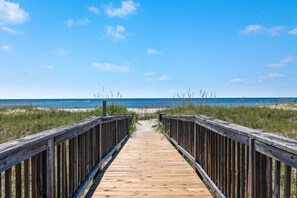 Walk along the weathered boardwalk to the serene beach.