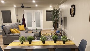 Un comedor con una mesa de madera, seis sillas y plantas en macetas.