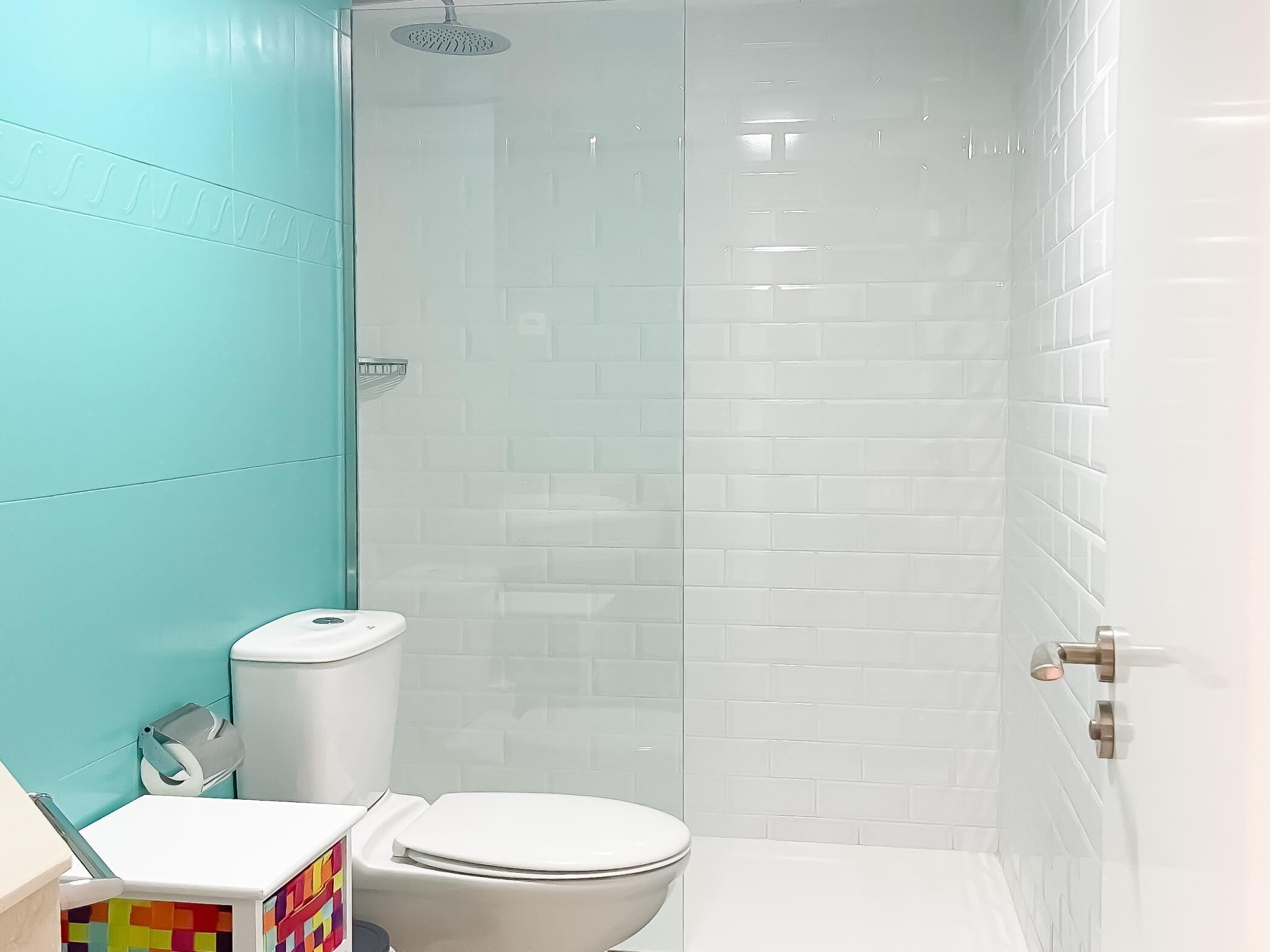 Et badeværelse med toilet, bruseniche og håndvask.