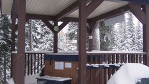A wooden gazebo with a clock, surrounded by snow-covered trees. - Ground Level, 2 Bedroom Suite - Close to Village and The Pond!  (Silver Star Mountain)