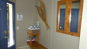 A bathroom with a blue door, a wooden bench, a wicker basket, and a mirror. - Ground Level, 2 Bedroom Suite - Close to Village and The Pond!  (Silver Star Mountain)