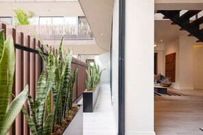 A modern interior with a long hallway, vertical wooden slats, and potted plants.